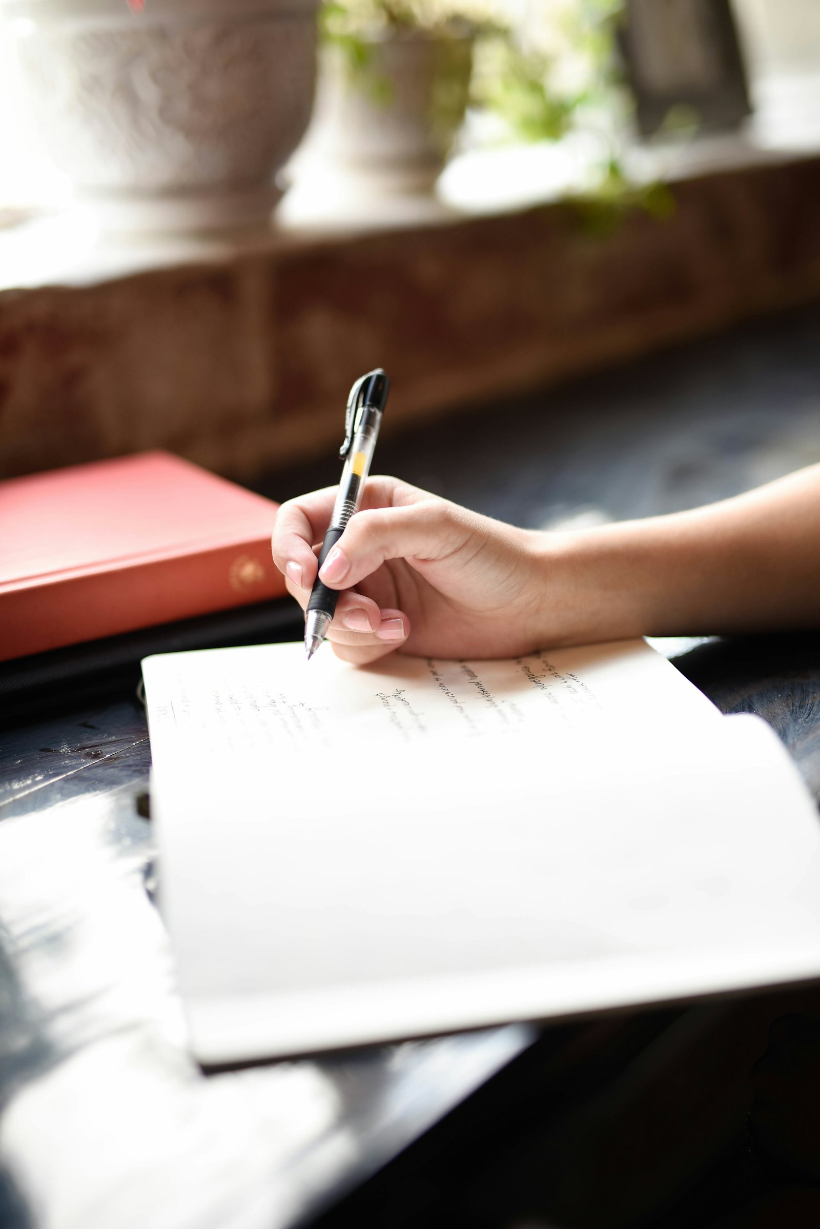 Mão escrevendo à mão em um caderno, o método que antecede a planilha