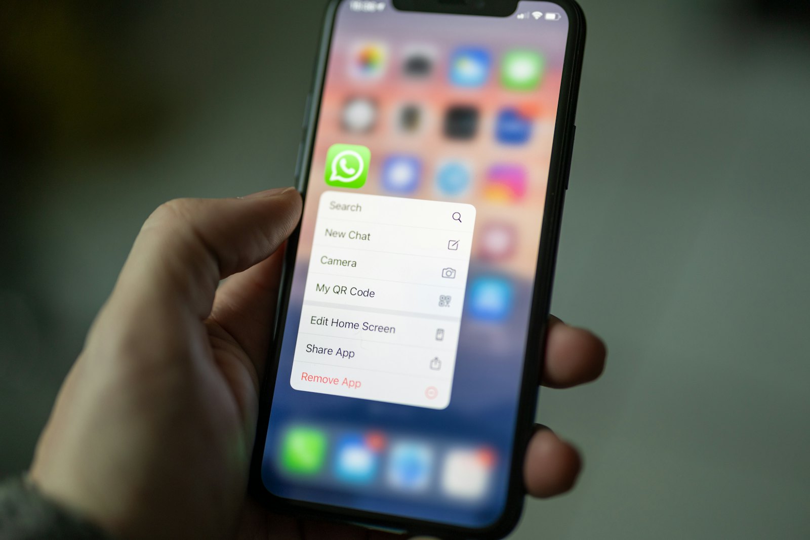 Mão segurando um celular com notificações de mensagens na tela